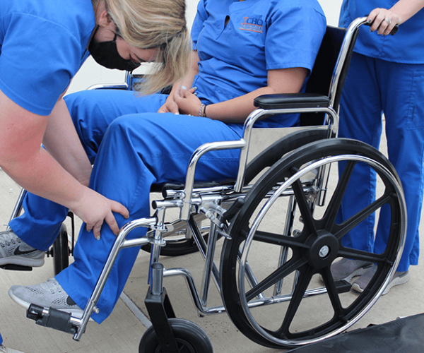 Physical Therapy Tech Placing Leg in Wheelchair